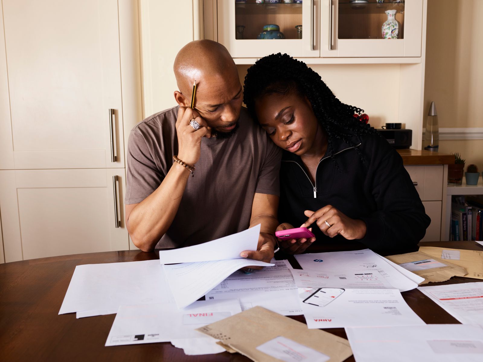 A couple reviewing a written bathroom proposal at a kitchen table